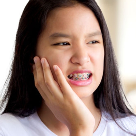 Patient experiencing discomfort from traditional braces treatment